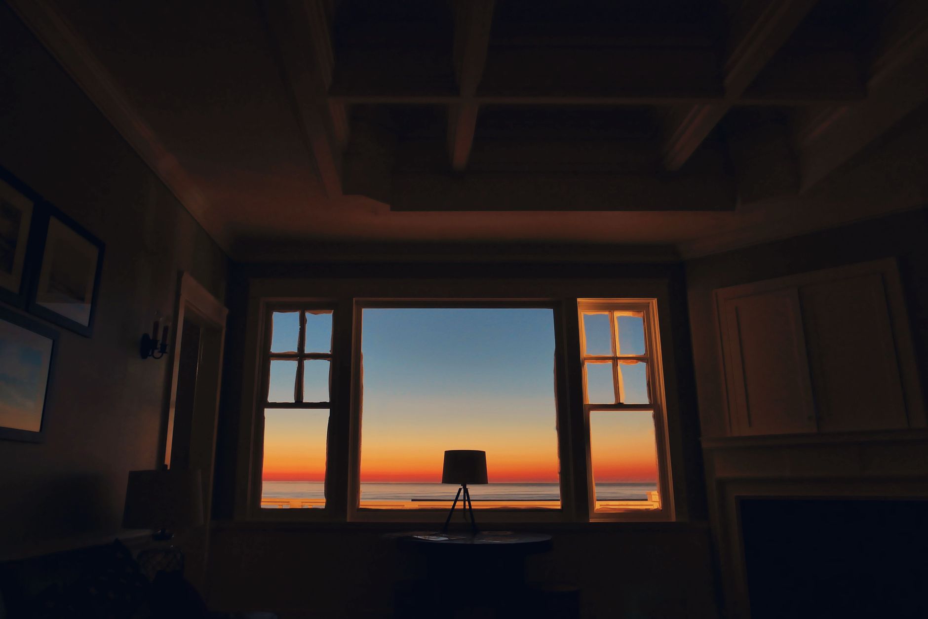 Dark silhouette of a room with a stunning sunset view through a window, creating an artistic interior in Carlsbad, CA